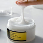 COSRX Advanced Snail 92 All in-1 Cream container with product on fingers